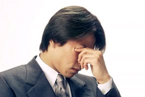 再発した痛風の痛みに耐えている男性